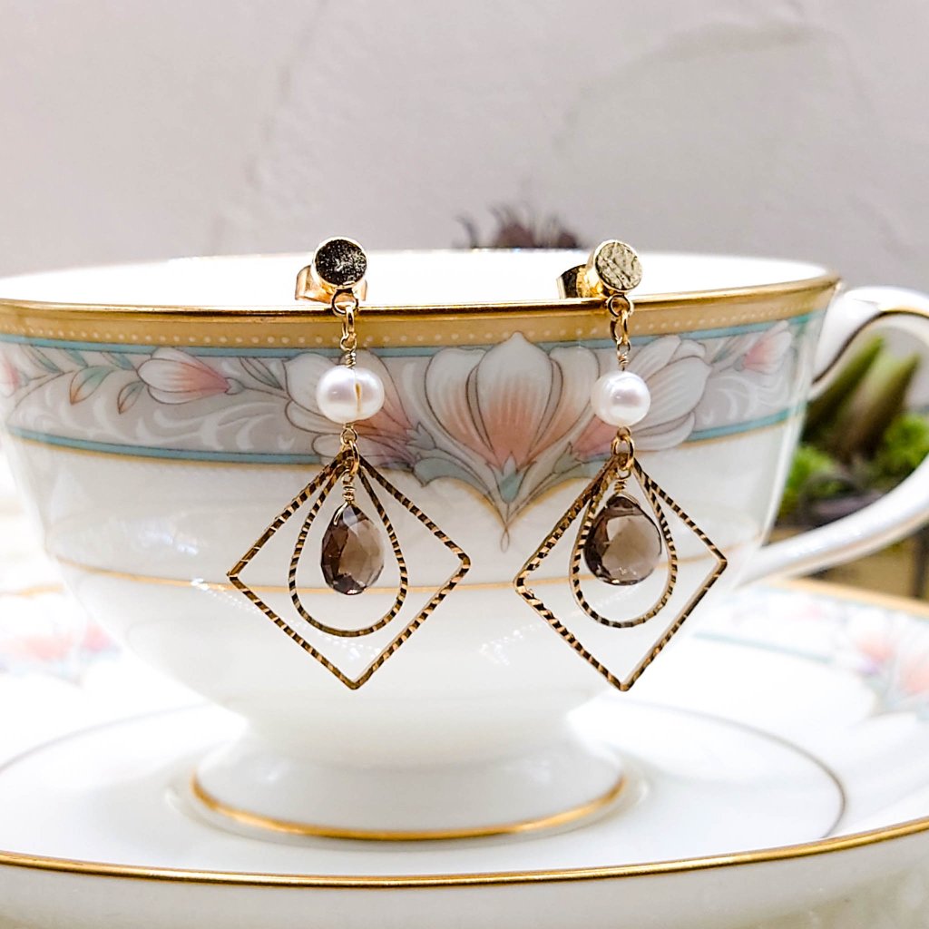 ダイヤ型と雫型の枠に囲まれた上品なスモーキークォーツのピアス ゴールドカラーの画像